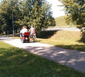 Mobilitates elekstroskūteris un velosipēdists brauc pa veloceliņu