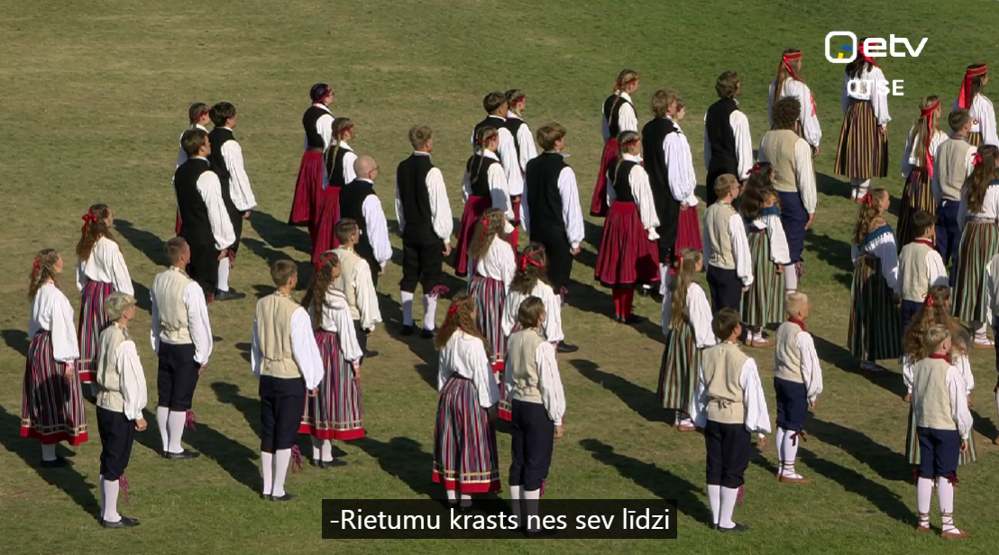 Ekrānā dejotāji, apakšā titri