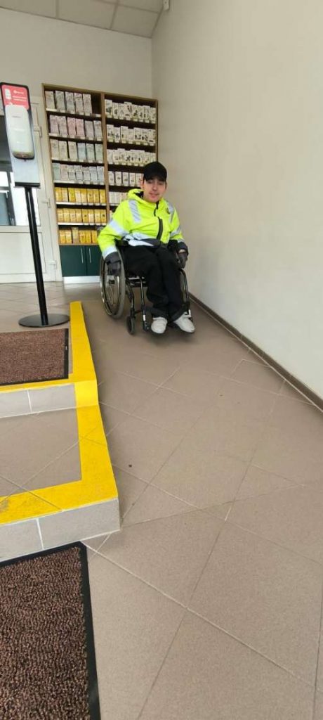 Voldemārs Lapa nobrauc no uzbrauktuves aptiekā, blakus ir ar dzeltenu krāsu marķētas kāpnes