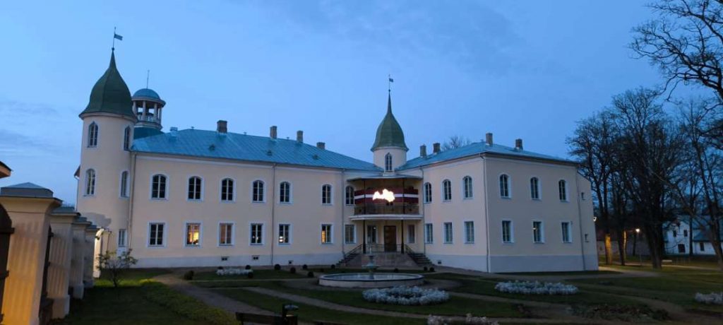 Krustpils pils ar Latvijas karogu un kontūru virs ieejas durvīm