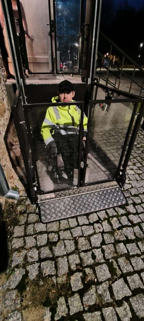 Voldemārs Lapa uz pelēkas krāsas pacēlāja, kurš ir iestiklots