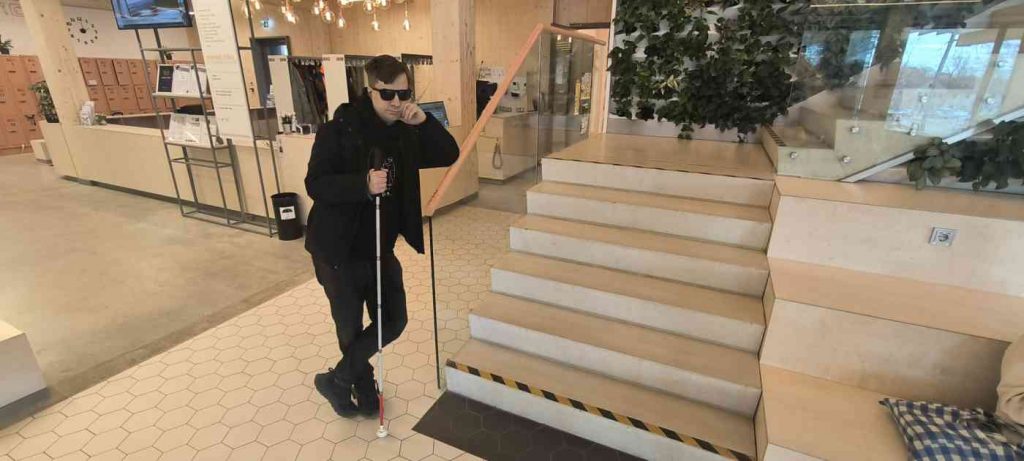 Reinis atspiedies pret stiklotu sienu blakus trepēm, kuras marķētas ar radioaktivitātes krāsas marķējuma lentu