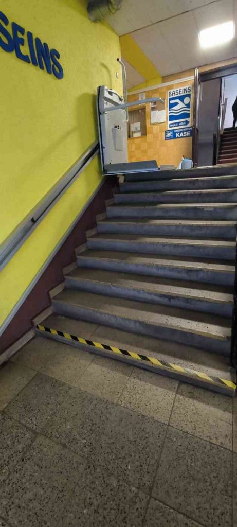 Pelēkas krāsas pacēlājs, trepes marķētas ar radioaktīvas krāsas marķējuma lentu, siena dzeltenzaļā krāsā