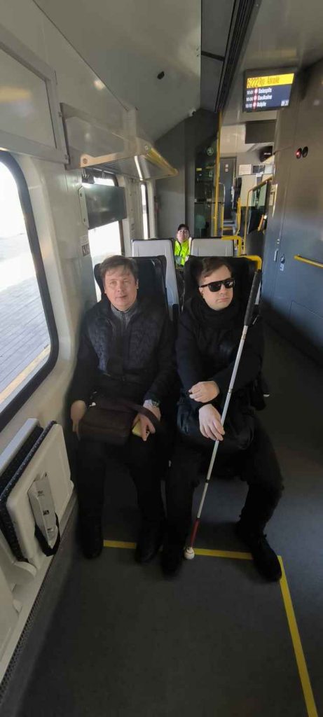 Reinis ar Raiti abi melnas krāsas apģērbos sēž vilcienā