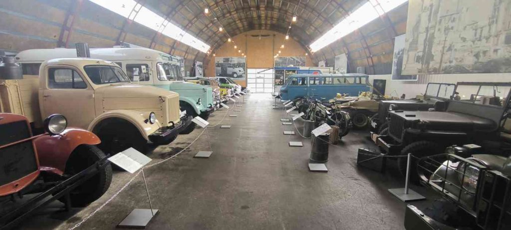 Angārā izvietoti daudz retro transporta līdzekļi, pie katra eksponāta ir apraksts